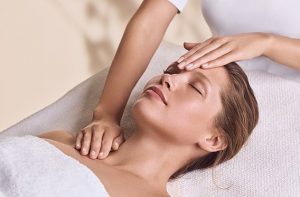 Beauty therapist providing a relaxing Clarins facial consultation and skincare treatment.